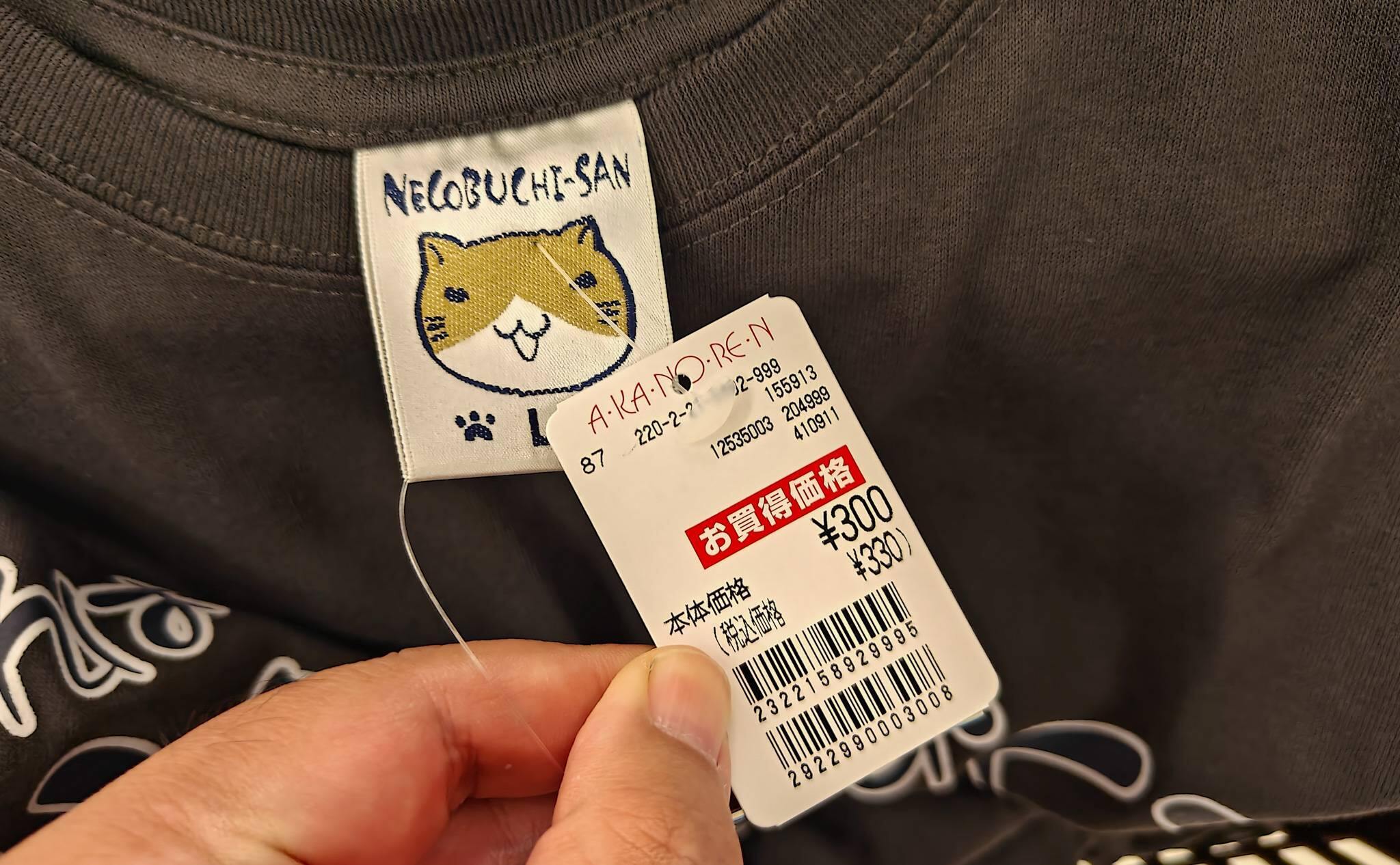 あかのれんのセールで、ハンガーにかけられた紳士用の柄物Tシャツ。<br>値札には税込み330円と書かれている